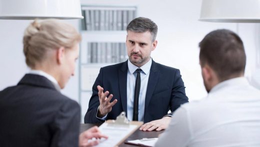 HR panel interviewing a candidate during a pre-hire background screening in a UAE office