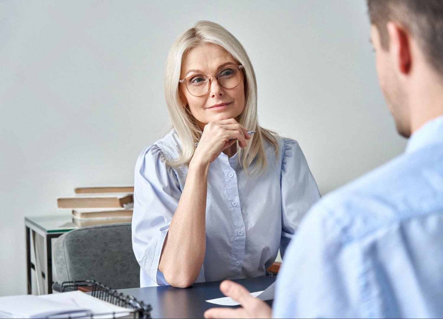 Senior compliance officer reviewing a reputational dossier during a client meeting